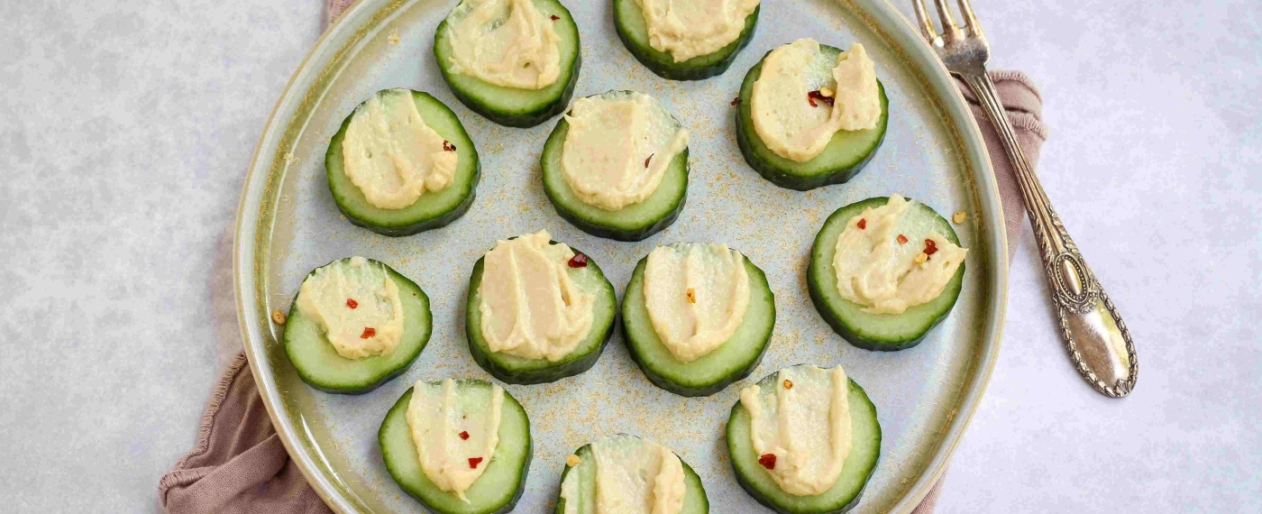 Plakjes komkommer met hummus