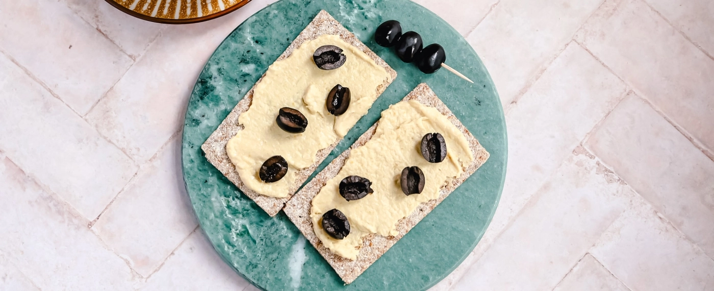 Crackers met hummus & olijven