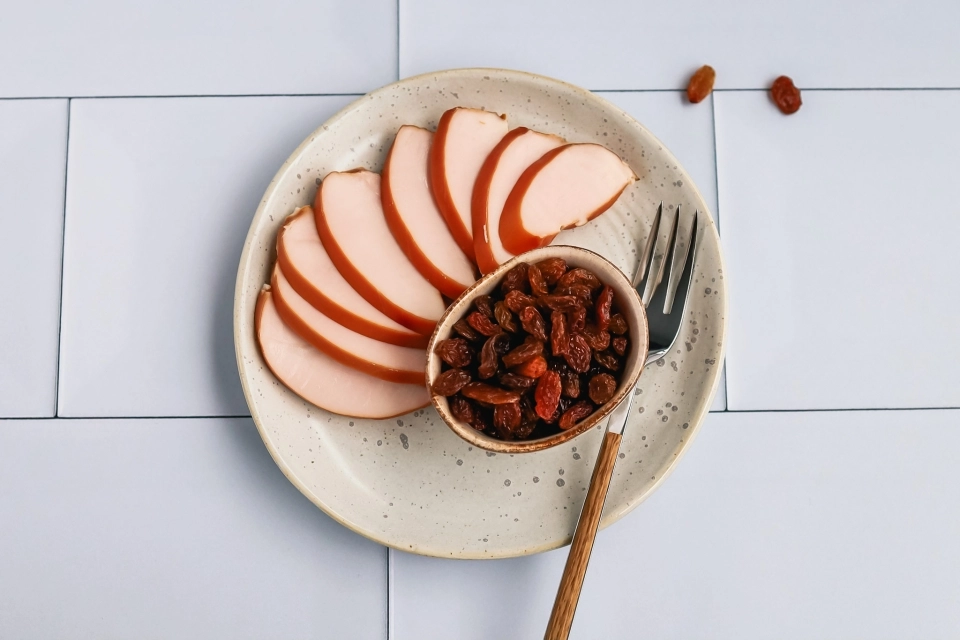 Plakjes gerookte kipfilet met handje rozijnen