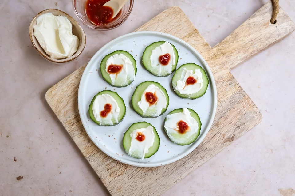 Plakjes komkommer met geitenkaasspread