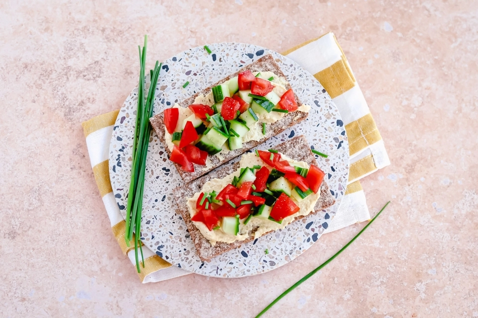 Crackers met hummus, tomaat & komkommer