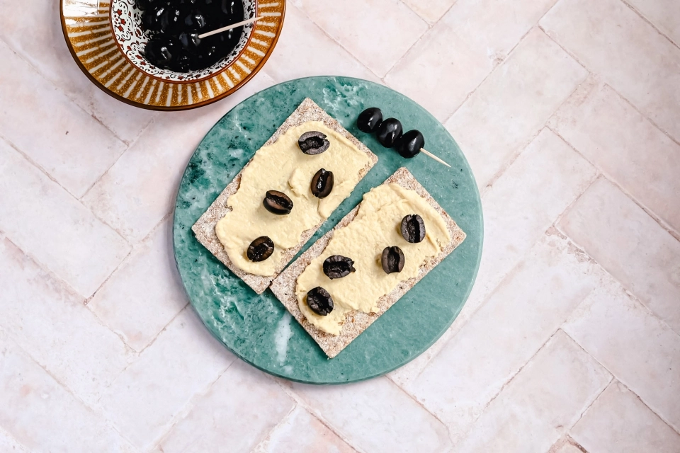 Crackers met hummus & olijven
