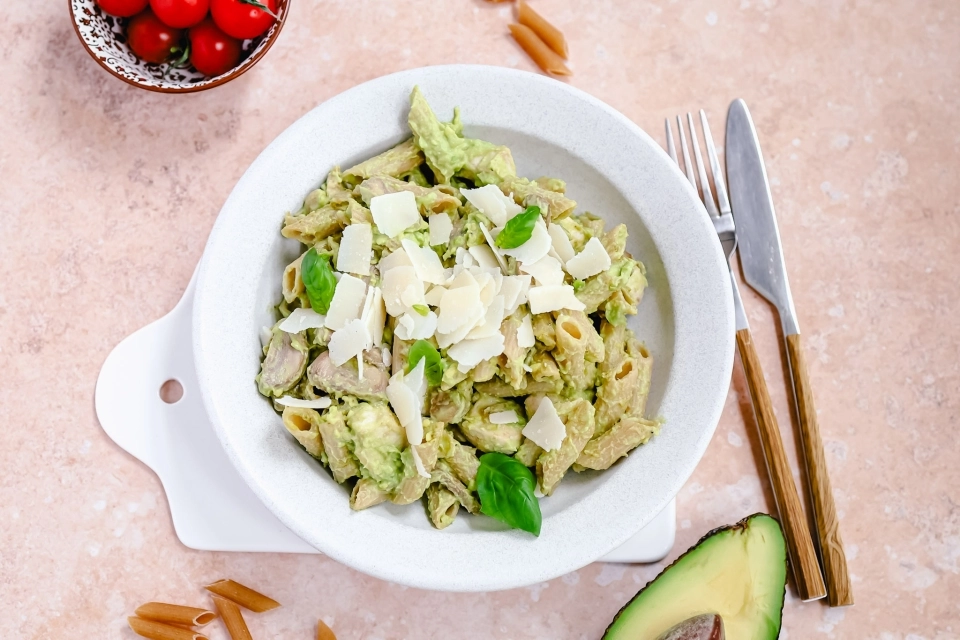 Penne in romige avocado-pestosaus met kip & champignons