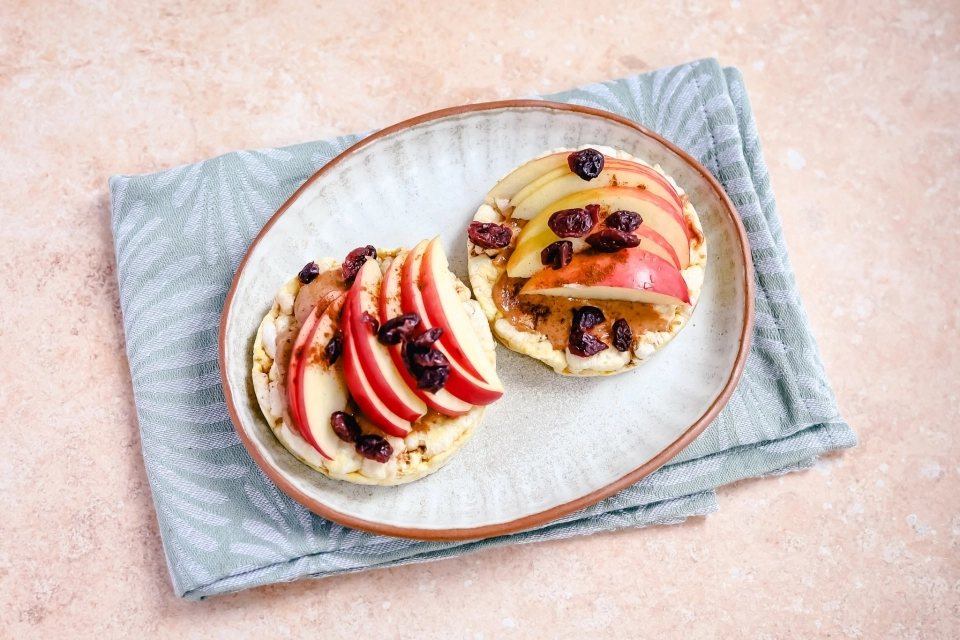 Maïswafels met pindakaas, appel & rozijnen