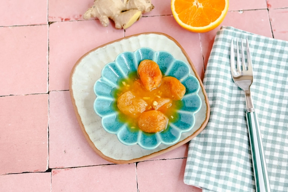 Gewelde abrikozen in sinaasappel & gembersap